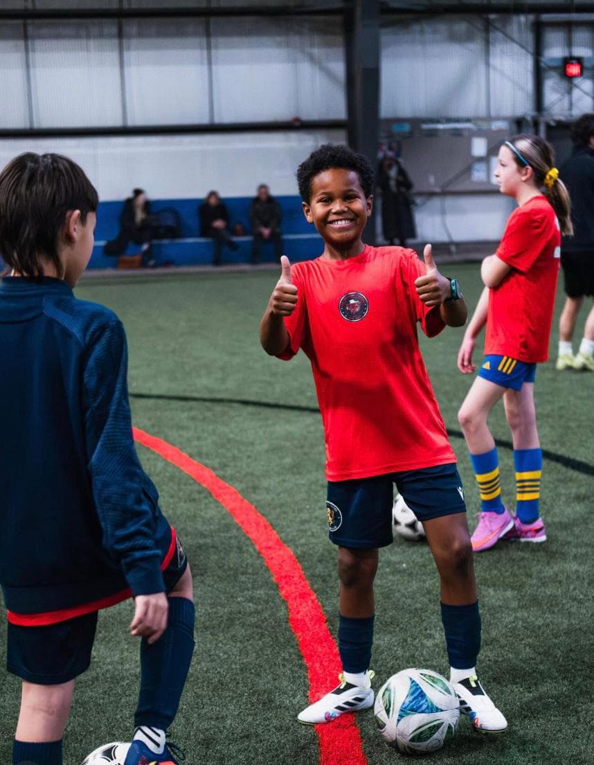 Boy in red kicking ball